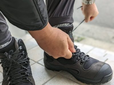 登山靴の靴紐を結ぶ人