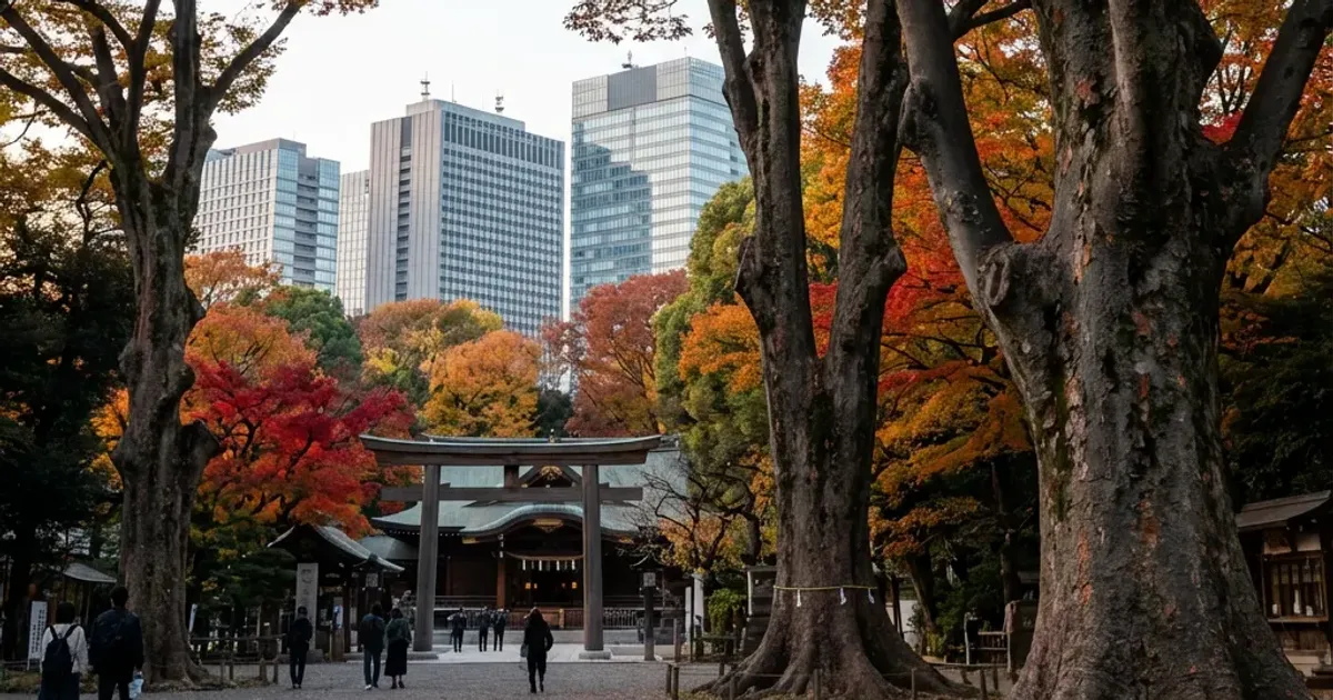 紅葉した大きな木と鳥居、その奥に見える高層ビル（東京23区の巨木のイメージ）